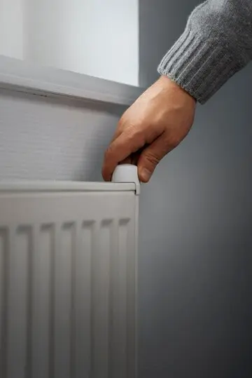 heating harmony: finding the perfect system for your home, man turning off radiator energy crisis