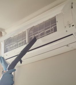 Technician cleaning ductless mini split air filter and coils during routine maintenance to improve airflow and system efficiency